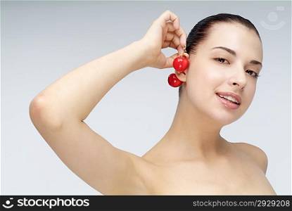 Close-up of young woman holding cherry