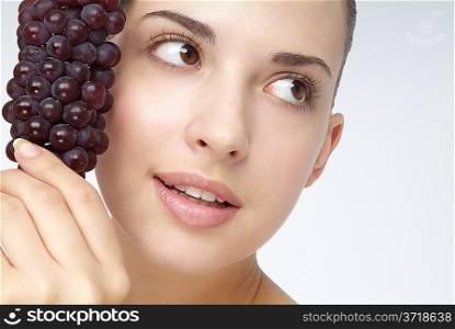 Close-up of young woman holding grapes