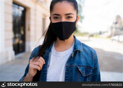 Close-up of young woman wearing face mask while standing outdoors on the street. Urban concept. New normal lifestyle concept.