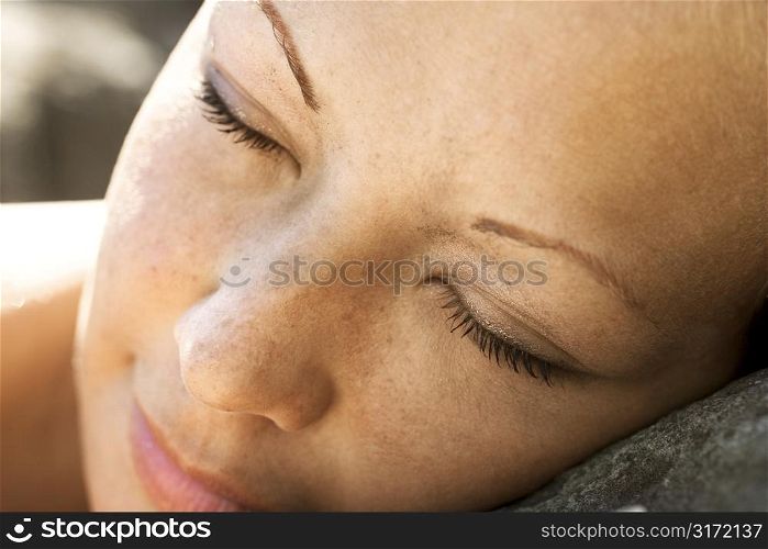 Close-up of young womans face with closed eyes.