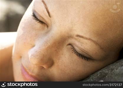 Close-up of young womans face with closed eyes.