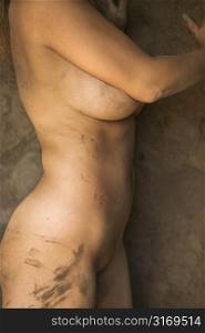 Close up of young womans muddy torso.