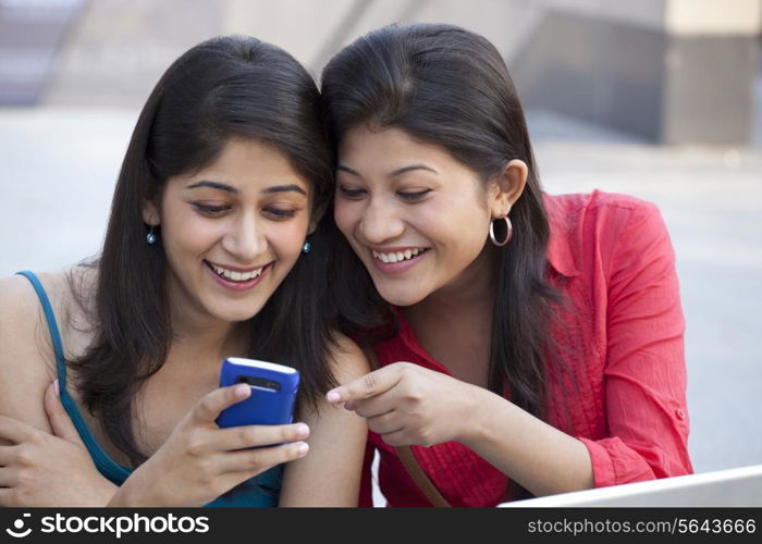 Close-up of young women using cell phone