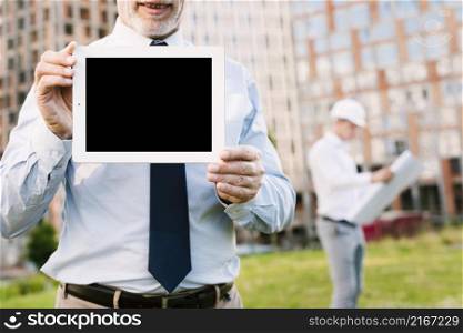 close up old man holding up tablet