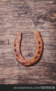 Close-up old rusty horseshoe on wooden background. Horseshoe for good luck
