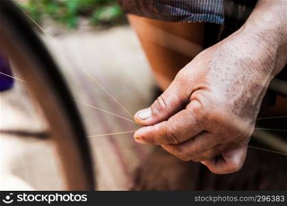 Close up old woman hand spun silk thread, traditional sericulture Thai silk making in Countryside, Thailand