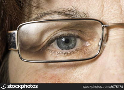 Close up old women blue eye and glasses