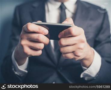 Close up on a businessman&rsquo;s hands as he is using a smartphone