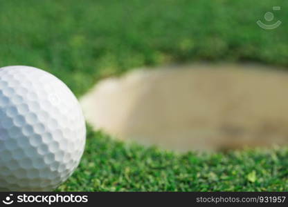 close-up on a golf ball on lip of cup