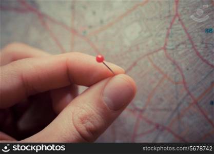 Close up on a hand placing a pin on a map