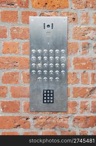 close-up on a intercom doorbell and access code panel on brick wall residential building