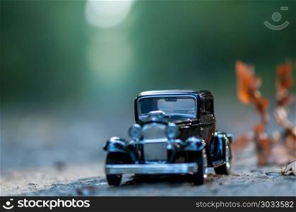 Close-up on a vintage car on a road in a forest. Childhood memories. Shallow depth of field.