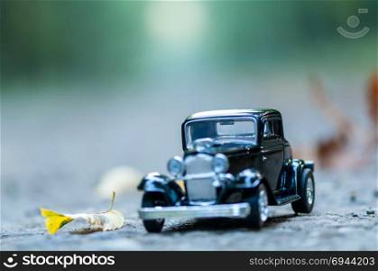 Close-up on a vintage car on a road in a forest. Childhood memories. Shallow depth of field.