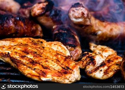 Close up on details of homemade chicken, pork steak and sausages on barbecue grill. Barbecue, grill and food concept.