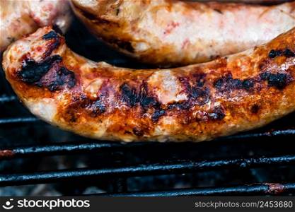 Close up on details of homemade sausages on barbecue grill. Barbecue, grill and food concept.