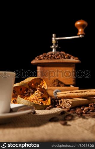 Close-up on dried orange fruit and cinnamon and coffee beans with coffee grinder on background. Close-up on dried orange fruit and cinnamon and coffee beans