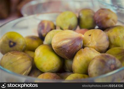 Close up on figs in a glass bowl.