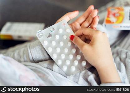 Close up on hands of unknown caucasian woman holding medicine drugs cure - Female taking supplement vitamins mineral while being sick at home - healthcare medicine covid-19 pandemic concept