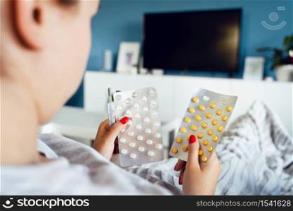 Close up on hands of unknown caucasian woman holding medicine drugs cure - Female taking supplement vitamins mineral while being sick at home - healthcare medicine covid-19 pandemic concept