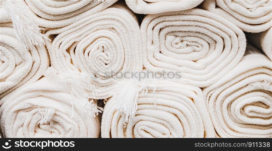 Close up on many stacking white carpet rolls.