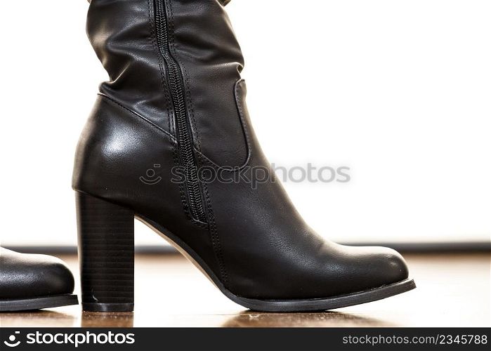 Close up on shiny black leather high heeled shoes. Long boots perfect for autumn. Fashion details concept.. Leather high heeled boots shoes