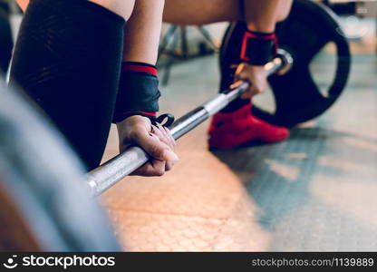 Close up on woman female athlete holding grip on the barbell at the gym ready for dead lift training work out bodybuilding strong power lifting