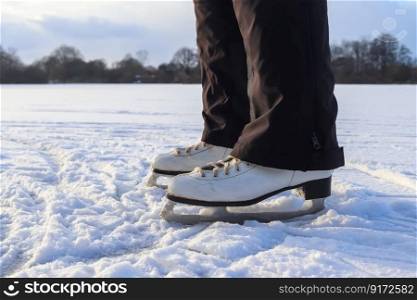 Close up on womans feet wearing ice skating boots and standing on ice