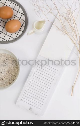 close up open notepad with raw egg flour milk