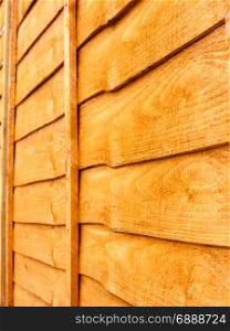 close up orange tinted wood fencing outside private texture and pattern