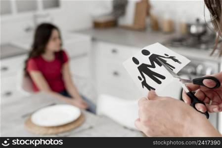 close up parent cutting paper family with scissors