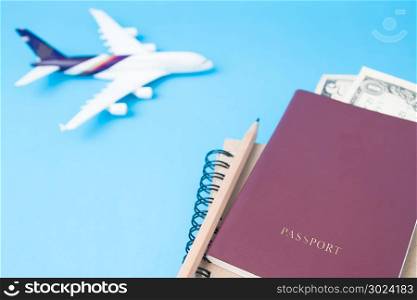 Close up passport book, money and diary with airplane model in background, Selective focus, Travel concept