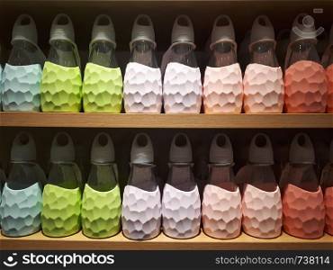 Close up pastel sport water bottles on shelf in shopping mall