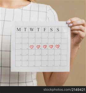 close up period calendar with drawn heart shapes