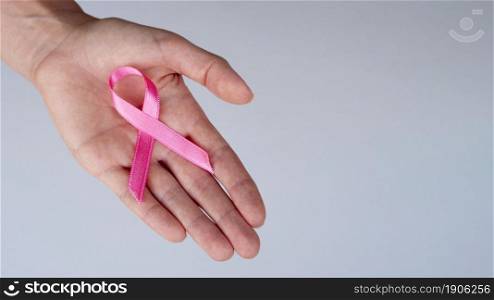 close up person holding pink ribbon. High resolution photo. close up person holding pink ribbon. High quality photo
