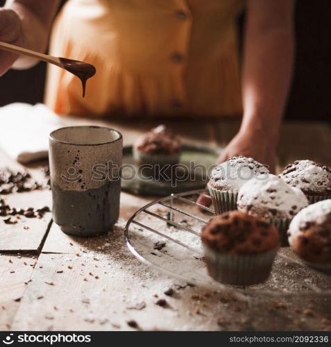 close up person preparing melt chocolate glass with cupcakes