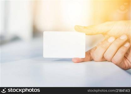 close up person s hand holding blank white card