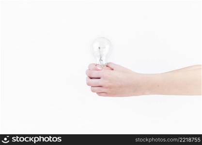 close up person s hand holding light bulb white backdrop