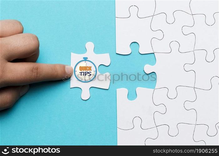 close up person touching white puzzle with quick tips text stop watch clock. High resolution photo. close up person touching white puzzle with quick tips text stop watch clock. High quality photo