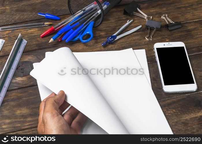 close up person turning page with stationeries mobile table