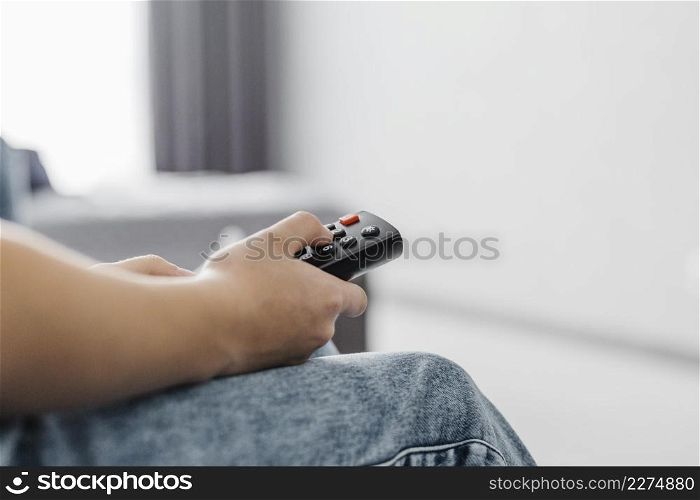 close up person using television remote
