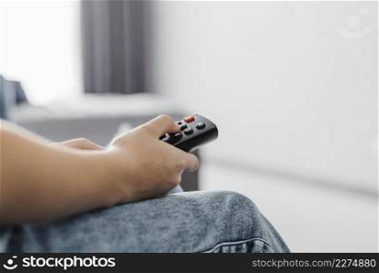 close up person using television remote