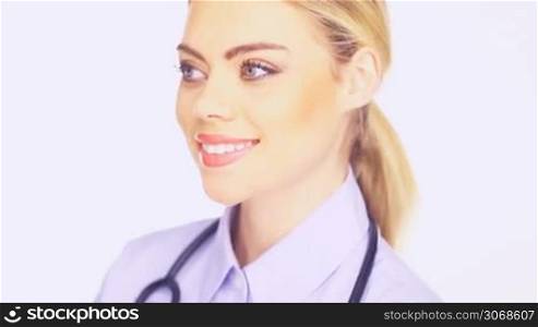 Close up pf the face of a beautiful young female doctor with stethoscope smiling at the camera