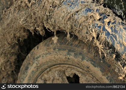 Close-up photo of a car covered with mud. Shallow depth of field.