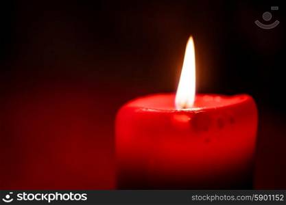 Close-up photo of a flaming red candlelight at christmas time