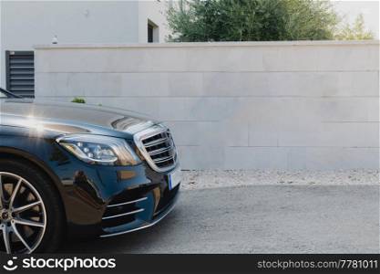 Close-up photo of a luxury car parked in front of a wall. High-quality photo. Close up photo of luxury car parked in front of a wall