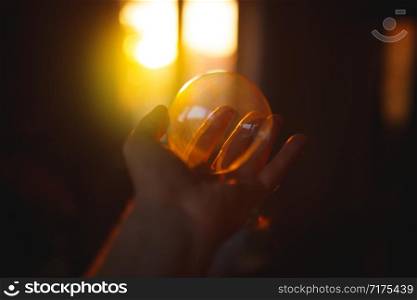 Close up photo of child holding soap bubble in hand in sunset light.. Close up photo of child holding soap bubble in hand in sunset light