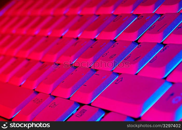 Close-up photo of the keyboard of an open notebook; blue red tone