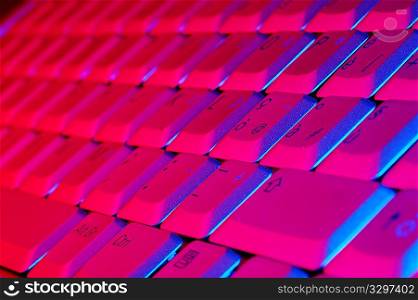 Close-up photo of the keyboard of an open notebook; blue red tone