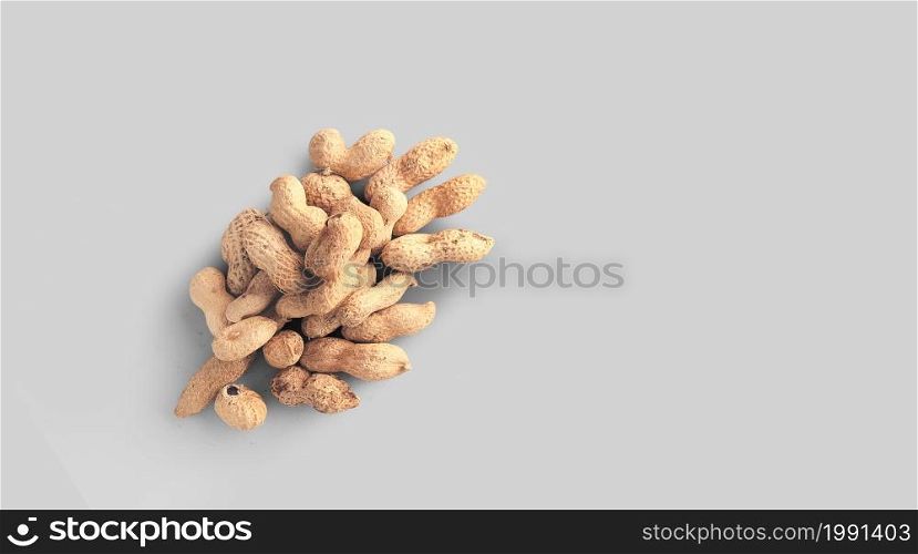 Close up photo of top view peanuts, raw peanuts in the nutshells isolated on grey background.