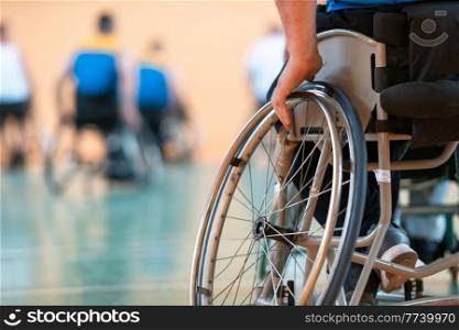Close up photo of wheelchairs and handicapped war veterans playing basketball on the court. Selective focus. . Close up photo of wheelchairs and handicapped war veterans playing basketball on the court
